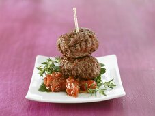 Two meatballs on tomato with herbs
