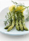 Four spears of green asparagus with potatoes and dill