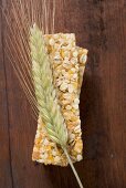 Muesli bars with ear of barley on wooden background