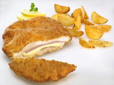 Chicken Cordon Bleu with potato wedges and lemon slices