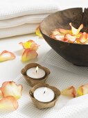 Rose petals in a wooden bowl and tealights