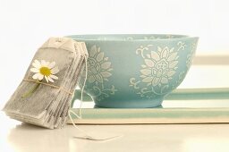 Tea bag with chamomile flower and drinking bowl