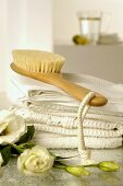 Towels and massage brush with lisianthus flowers