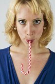 Blond woman with a candy cane in her mouth