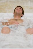 Young man lying in whirlpool