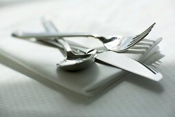 Knife, fork and spoon on napkin