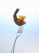 Prawn with parsley and tomato on a fork