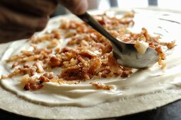 Putting bacon on a tarte flambée