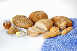 Verschiedene Brote und Brötchen mit Butter und Marmelade