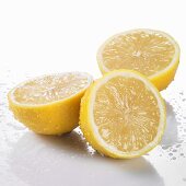 Drei Zitronenhälften mit Wassertropfen