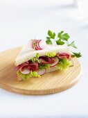 A ham, lettuce and radish sandwich