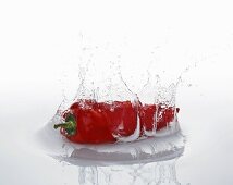 Rote Chilischote fällt ins Wasser