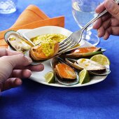 Taking mussels and dip out of shell with a fork