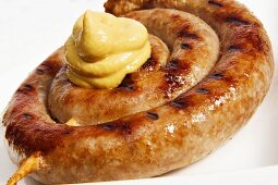 Coiled sausage with blob of mustard