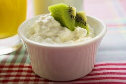 Cottage cheese and pieces of kiwi fruit in a small bowl