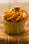 Muffin mit orangefarbener Cremehaube
