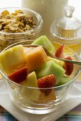 Fruit salad, cereal and honey for a healthy breakfast