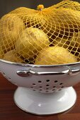 Potatoes in net lying in colander