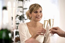 Young woman clinking glass of champagne