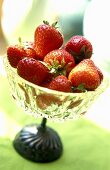 Fresh strawberries in a stemmed glass bowl