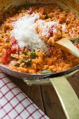 Tomato risotto with basil and grated cheese