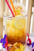 Cuba Libre with slice of lemon and amaryllis flower
