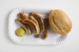 Small sausages with mustard and bread roll