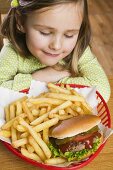 Small girl with hamburger and chips