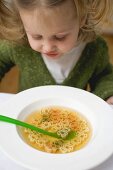 Small girl with teddy bear noodle soup