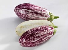 Two striped aubergines, one halved