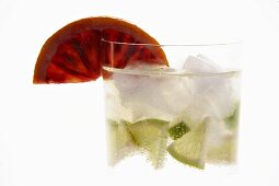 Mineral water with lime wedges, ice cubes and blood orange