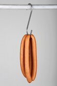 Two pairs of frankfurters on a hook