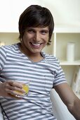 Young man holding a glass of juice in his hand