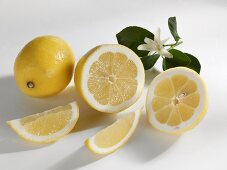 Ganze und halbierte Zitrone mit Zitronenspalten
