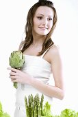 Young woman holding an artichoke