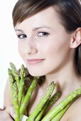 Young woman holding green asparagus