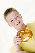 Boy holding a bitten pretzel in his hand