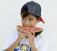 Boy biting into a slice of watermelon