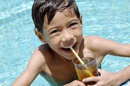 Junge trinkt Eistee im Pool