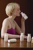Young woman with vitamin-rich milk drinks
