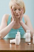 Young, blond woman sitting in front of plastic bottles