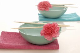 Asian bowls with chopsticks and flowers