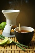 Aroma lamp, bowl of tea and limes
