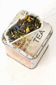 Tea tin and small porcelain scoop containing tea mixture
