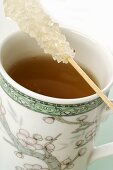 Mug of tea with sugar swizzle stick (close-up)
