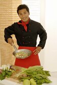 Asian chef with wok frying pan