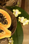 Papaya, halved, in wooden bowl