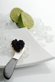 Kaviar auf Perlmuttlöffel, zerstossenes Eis, Limetten
