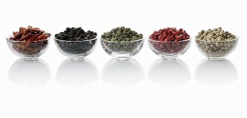 Four different types of peppercorns and dried chillies