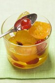 Candied fruit with mustard in glass with spoon